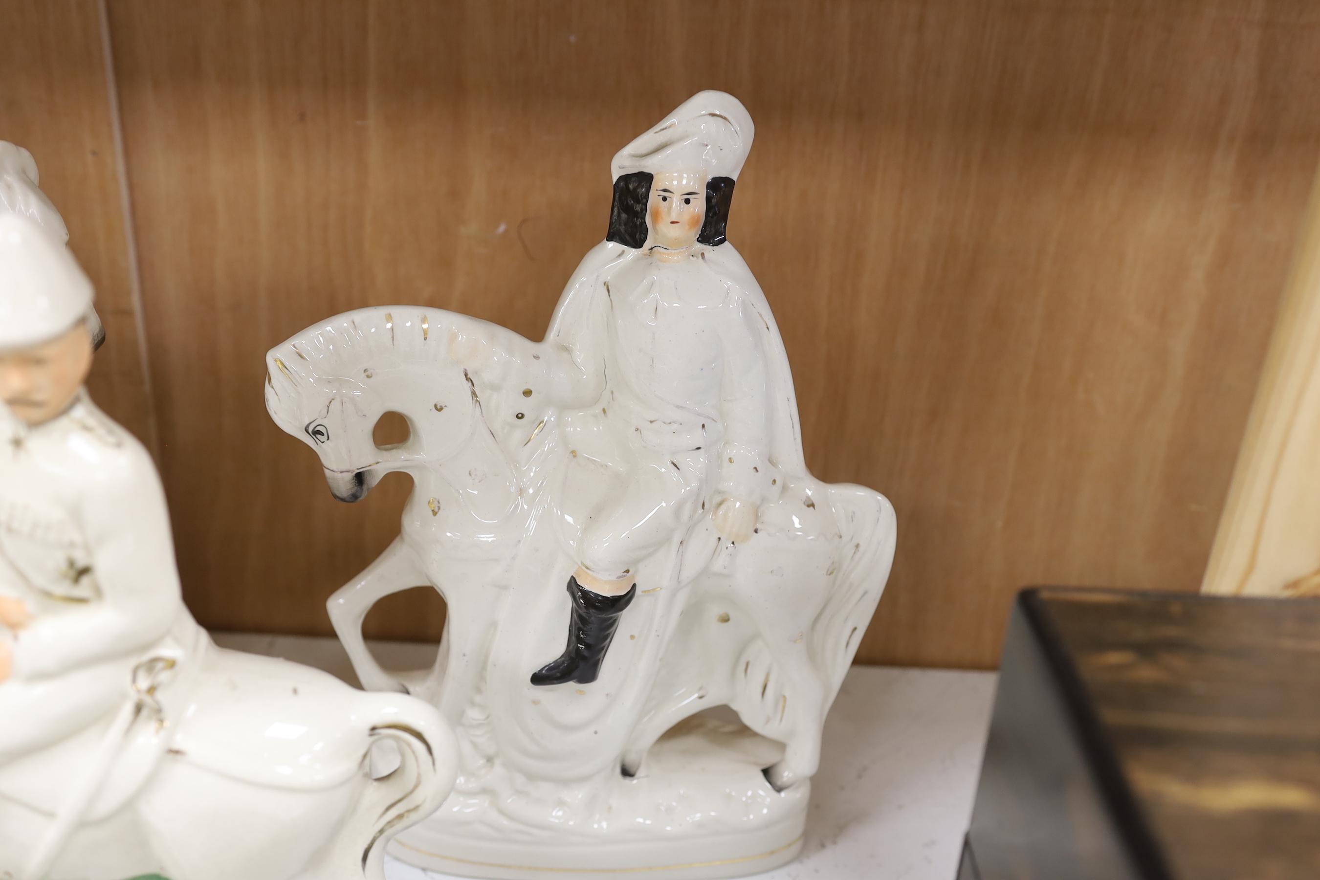 A pair of Staffordshire cow herder figure groups and three Staffordshire equestrian groups, tallest 38cm high